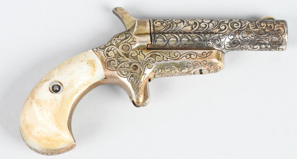 SUPERB ENGRAVED COLT 3RD MODEL DERINGER: Serial #14628. Barrel length 2.5". Caliber .41 Rimfire. Made 1870-1912. It was engraved by H.E. Putney inside grip frame. The engraving is a deep relief hand cut master engraving with full coverage. A