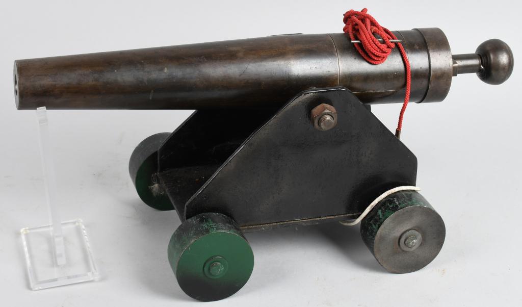 VINTAGE NAVAL SIGNAL OR LINE THROWING CANNON: Small cannon on four-wheel carriage with red lanyard. No apparent markings. Barrel measures approximately 18" long, approximately 11" across. Shows age and discoloration to the metal. Excellent