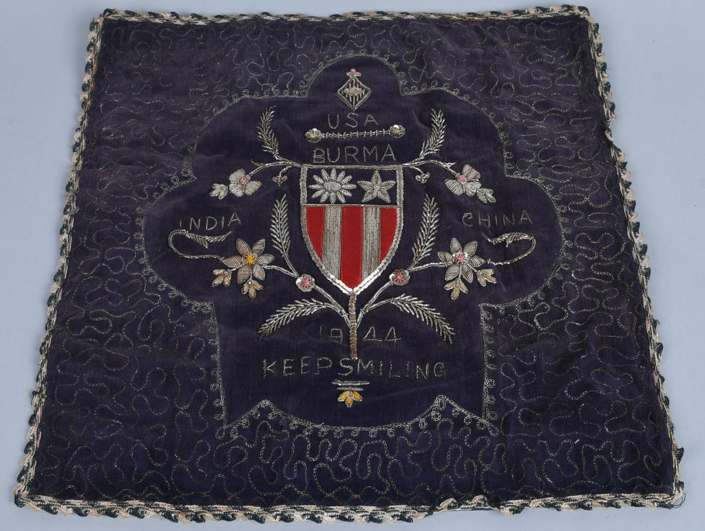 WWII CHINA BURMA INDIA CBI SOUVENIR TAPESTRY: 16" x 16" embroidered tapestry / wall hanging with CB I insignia, floral pattern, and the words "USA CHINA BURMA INDIA" and "KEEP SMILING." Features chain lin, sequin, and felt on what appears to be a
