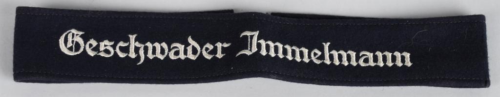 WWII NAZI LUFTWAFFE GESCHWADER IMMELMANN CUFFTITLE: EM/NCO's pattern deep navy blue woven wool construction cuff title with machine embroidered Gothic script: "Geschwader Immelmann" in silvery/gray threads. The cuff title is approximately 36mm wide and