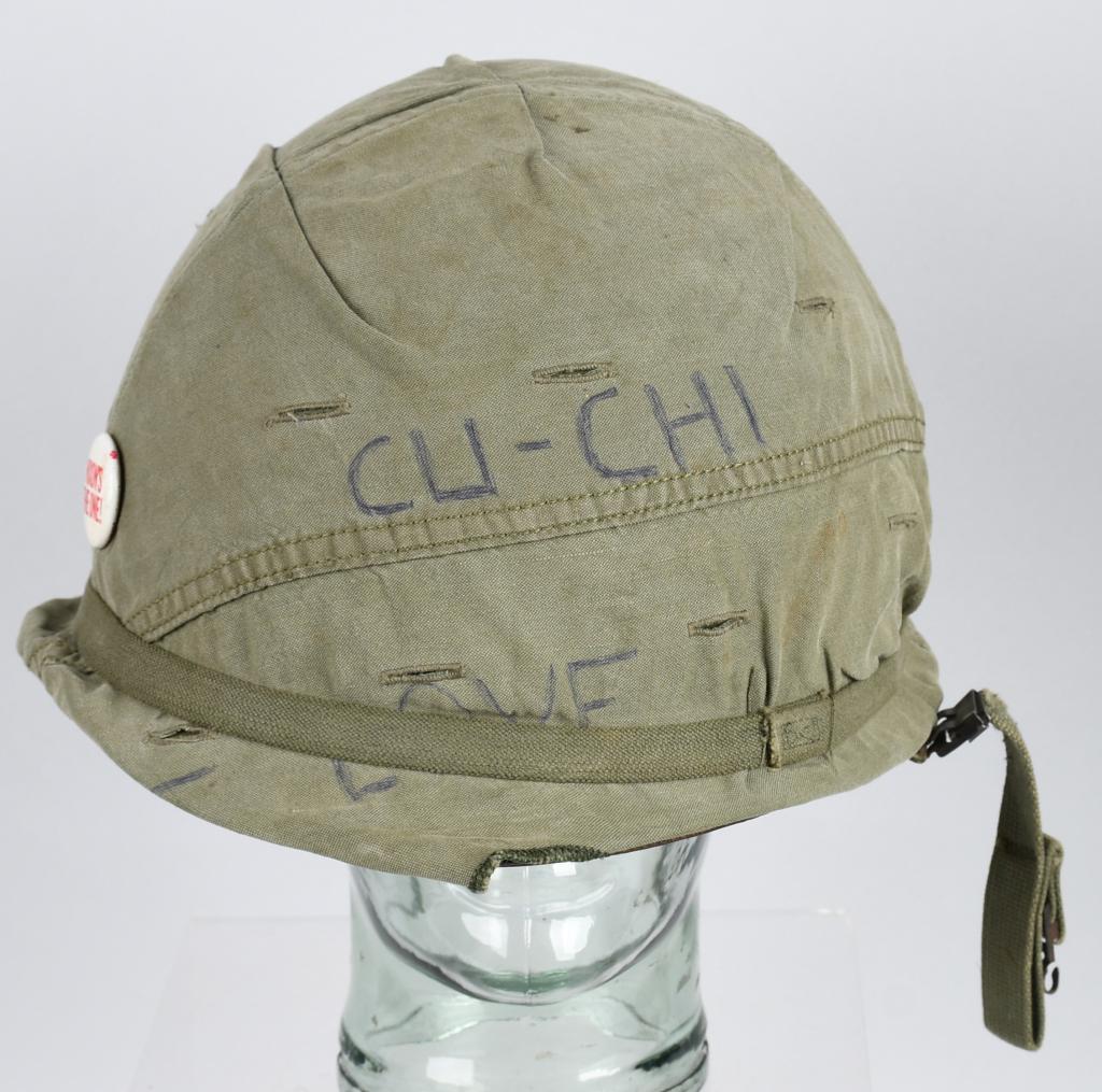 VIETNAM US ARMY HELMET WITH OD COVER PERSONALIZED: Vietnam war era US M1 "Steel Pot" helmet with rare OD green cover with foliage slits. Swivel bale, metal clip on OD green chinstraps. Cover has pen ink graffiti and a "Nixon's the One!" political butt