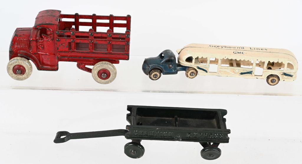 3- VINTAGE cast iron TOYS: Lot includes 3 1920's and 1930's cast iron toys. Lot includes a original paint 5 3/4" Hubley Stake truck. a 7 1/2" Arcade Greyhound Lines GMC bus, and a repainted Champion Express Wagon. The Hubley st