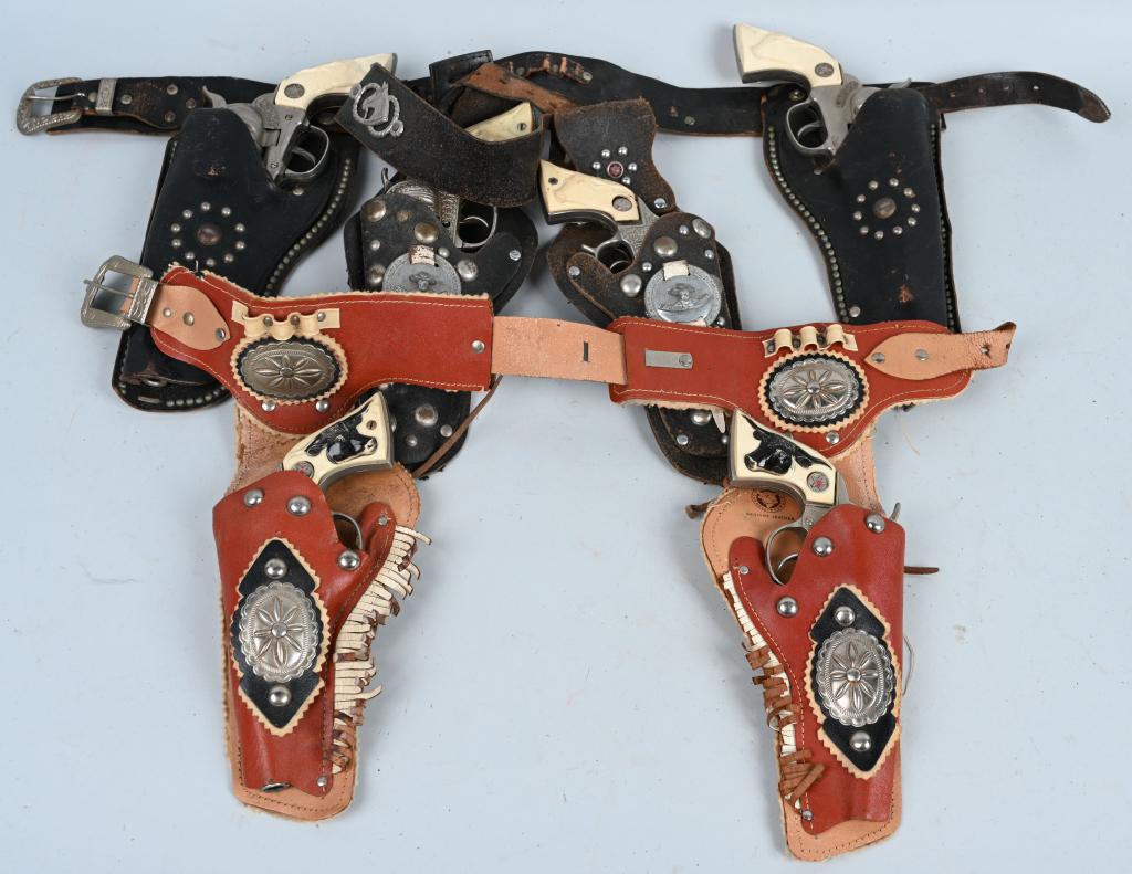 6- HUBLEY TOY CAP PISTOLS w/ HOLSTERS: Lot includes 2 Cowboy, 2 Western and 2 cast iron Texan Jr. pistols. All worked when tested. Have general wear and one has a broken hammer hammer spur. Holsters show wear. Good-Very Good