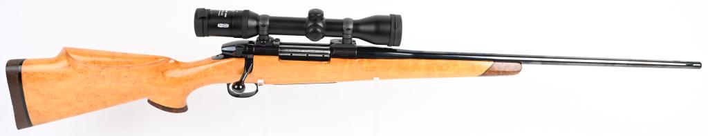 WEATHERBY MARK V BOLT ACTION RIFLE: SERIAL H80960. BARREL 24". CALIBER .300 MAGNUM. Features a non-checkered Birds Eye Maple stock with rosewood fore-end tip and grip cap. Other features include a factory high polish blue barrel and fra