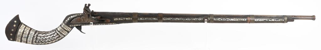 ORNATE MIDDLE EASTERN LONG BARREL FLINTLOCK RIFLE: Upwards of one hundred little pearl inlays really set this rifle apart. It has a 40" trumpet barrel, five brass barrel bands, flintlock with a stock that is almost completely covered in pearl hand cut