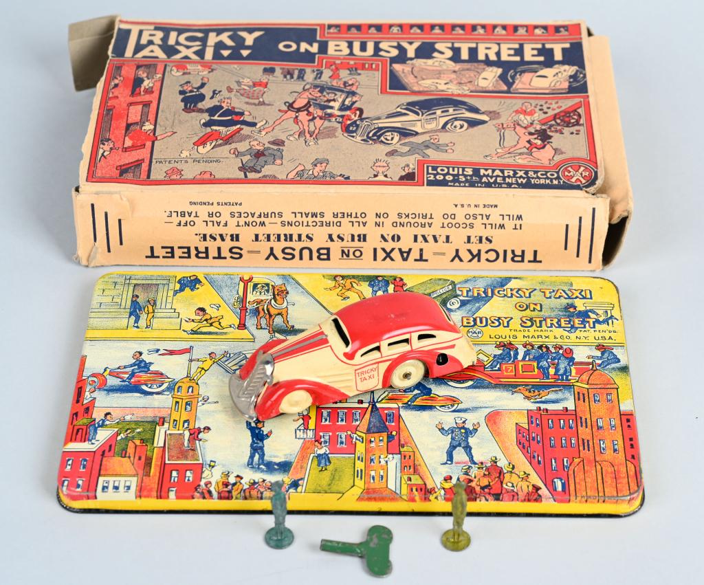 MARX tin windup TRICKY TAXI on BUSY STREET w/ BOX: Great looking 1930's tin toy with the original graphic box. The taxi is 4 1/2" and worked when tested. The tin base is about 10" by 6". This set also includes two lead boys. The box has general wear a