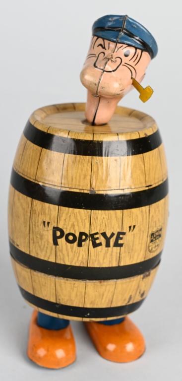 CHEIN Tin Windup POPEYE IN THE BARREL: Wonderful early Popeye toy. Popeye waddles around wearing a barrel. All original with very nice color and shine. Windup works. 7" Excellent
