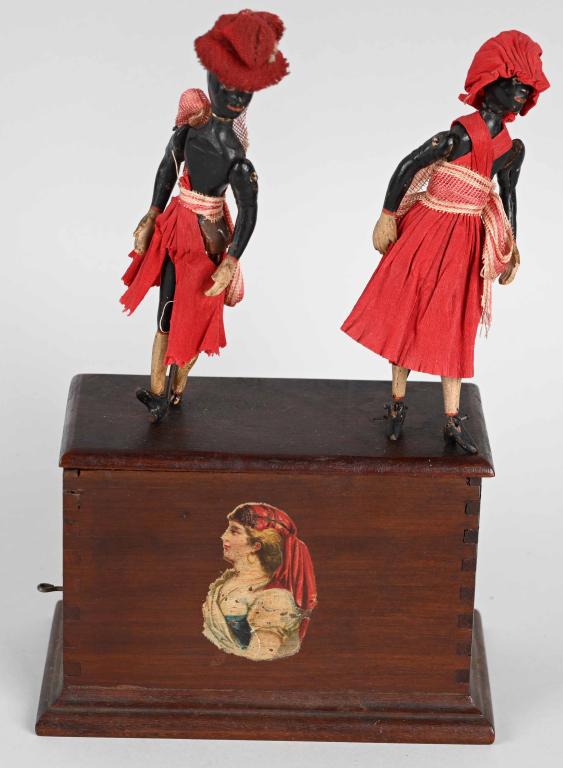 IVES Clockwork DOUBLE JUBILEE DANCERS: Early Ives clockwork Double Jubilee Dancers. Black Man and Woman dance on wooden box. All original with nice finish and decals of woman on the box. Both figures have nice faces and matching clothing. 