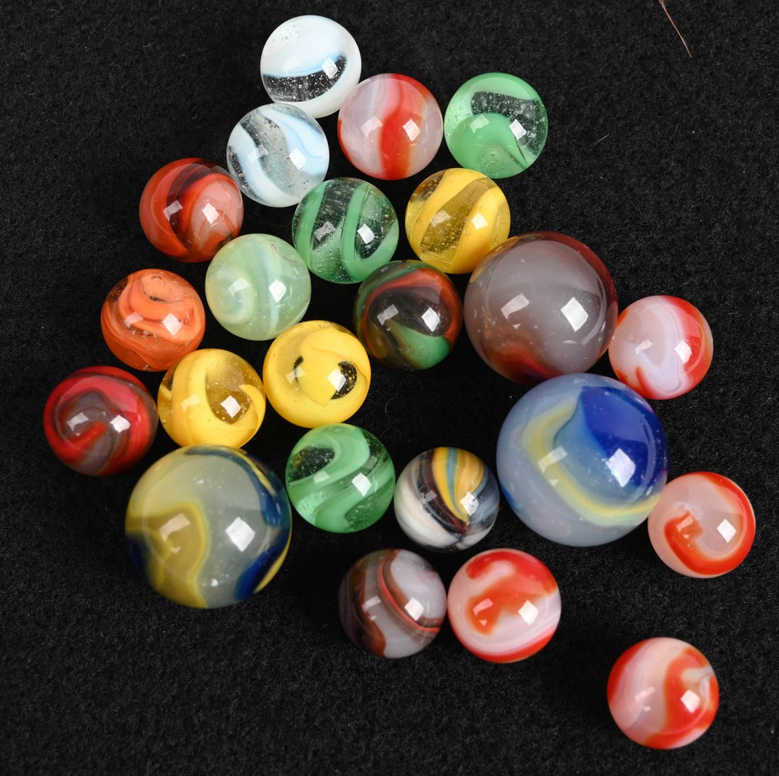 ASSORTED AKRO AGATE AND CORKSCREWS: Lot contains 23 assorted marbles. Size 5/8" to 1". Near Mint to Mint