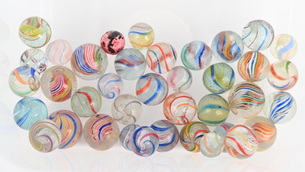 38- HANDMADE MARBLES: Lot includes 37 multi color swirls including latticino, divided,a nd solid core swirls. Also included is a pewee pink bennington. Size 1/2" to 13/16" diameter. Very Good-Excellent