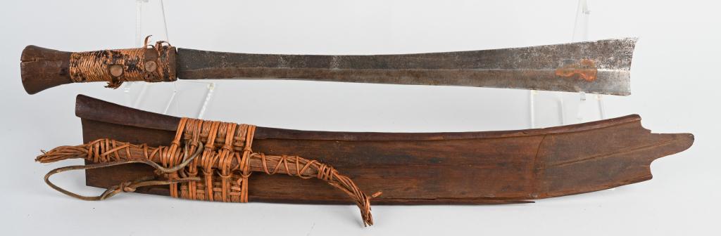 19th CENTURY NEPALESE CANE KNIFE WITH SHEATH: 17" blade, 23" overall length, with wrapped handle and copper rivets. Comes with original wooden sheath. Cording on grip has come loose. Good-Very Good