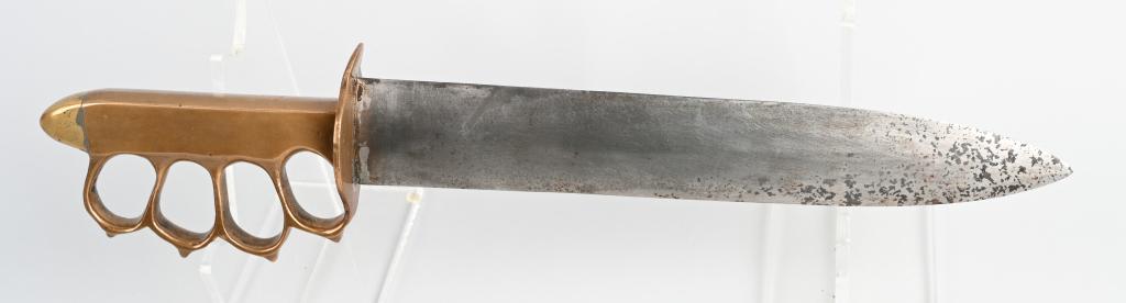WWII US THEATER MADE TRENCH KNIFE KNUCKLEDUSTER: Unique combat knife in the form of a 1918 "knuckleduster" trench knife with brass knuckle grip, pyramid pommel, and a large spear point blade. Unmarked. 11.4" blade, 16.5" overall length. Blade shows 