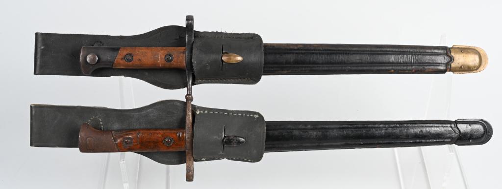 2 WWII ITALIAN MILITARY RIFLE BAYONETS: Pair of early Italian military rifle bayonets. Both have leather scabbards, wood grips, and leather frogs. 1- Italian Carcano bayonet with brass fittings. Modified pommel is beveled to fit the VV70 Ve