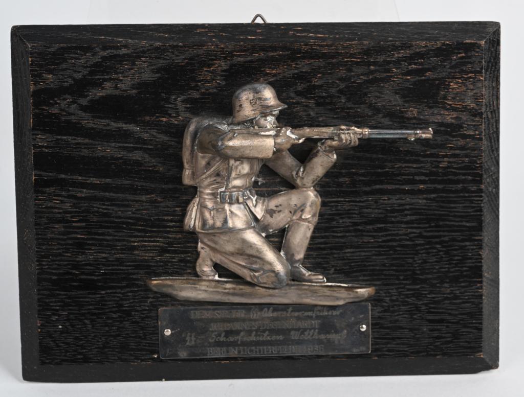 WWII WAFFEN SS SHOOTING AWARD 1936 DATED & NAMED: Attractive, WWII Nazi German Waffen SS shooting trophy measuring 9 X 7 inches and depicts a kneeling soldier that is fully equipped while holding a rifle. Underneath having the inscription DEM SIEGER 