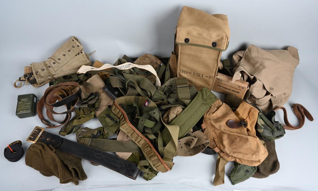 MIXED LOT MILITARY FIELD GEAR WWII to DESERT STORM: Large mixed-conflict lot of field gear and equipment from World War II, Korea, Vietnam, and Desert Storm. Includes a radio carrier, a brass buckled Sam Browne belt, carrying cases for cleaning gear in