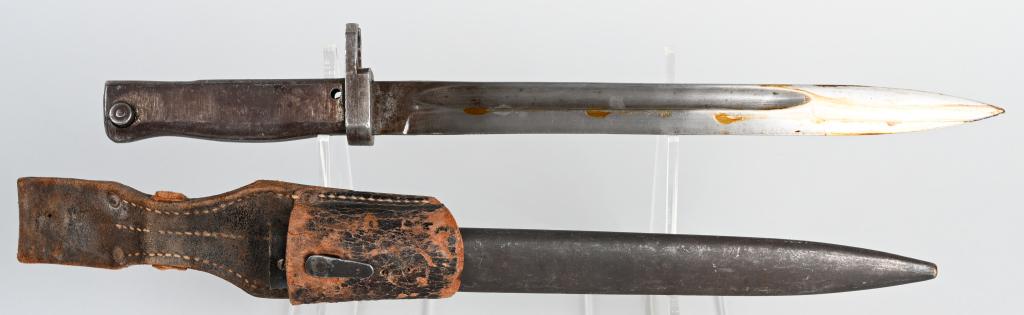 WW1 IMPERIAL GERMAN ERSATZ COMBAT BAYONET: An "ersatz" M1916 German (substitute) bayonet and its scabbard made in answer to shortages by a machine shop from stamped or cast parts. Roughly 25cm blade. Typical metal grip. Ersatz, crude, scabbard
