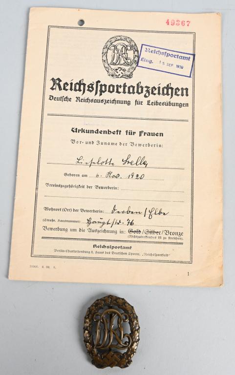 WWII NAZI GERMAN DRL SPORTS BADGE & DOCUMENT: Award document and a 1937 pattern die struck bronze award. The badge is in the form of a vertical oval oak leaf wreath, with a mobile swastika and bow to its base, encompassing the stylized, cut-out l