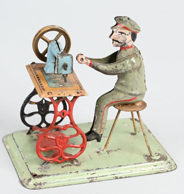 GERMAN STEAM TOY ACCESSORY MAN AT SEWING MACHINE: Original steam toy accessory. Man at sewing machine. All original. Machine loose at legs on one side. 4" Very Good