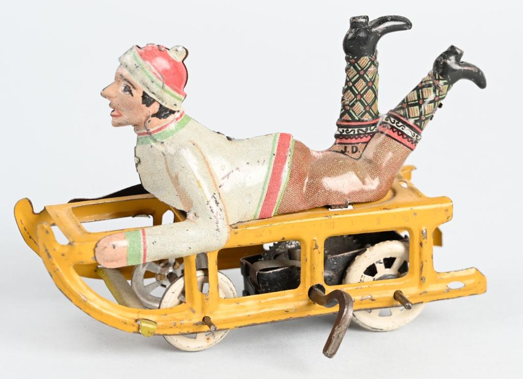 GERMAN TIN WINDUP BOY ON SLED: All original and working. 4 1/2" Excellent