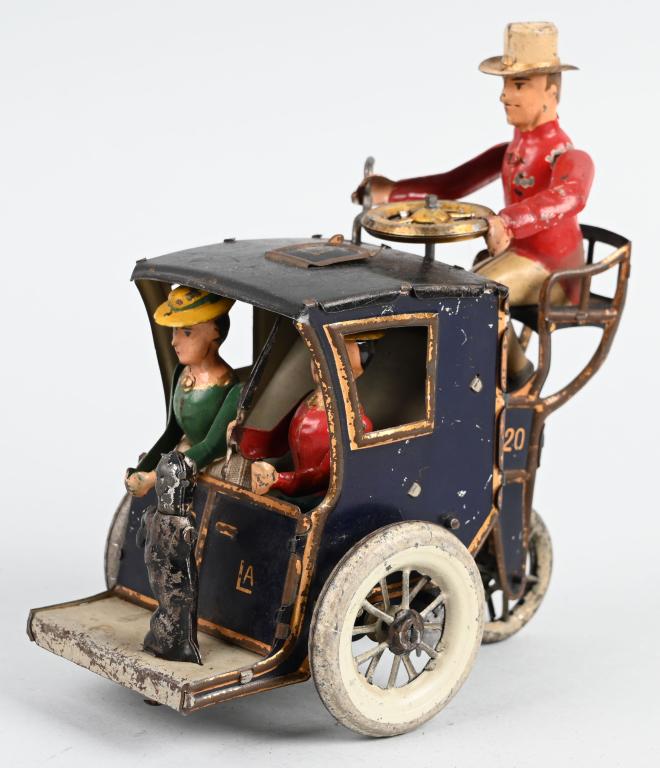 LEHMANN TIN WINDUP LILA HANDSOM CAB: Very nice tin windup LiLa Handsome Cab. All original and complete with Driver, 2 Lady Passengers, and Dog. Toy works with wonderful actions. Desirable dark blue version. 6" Excellent