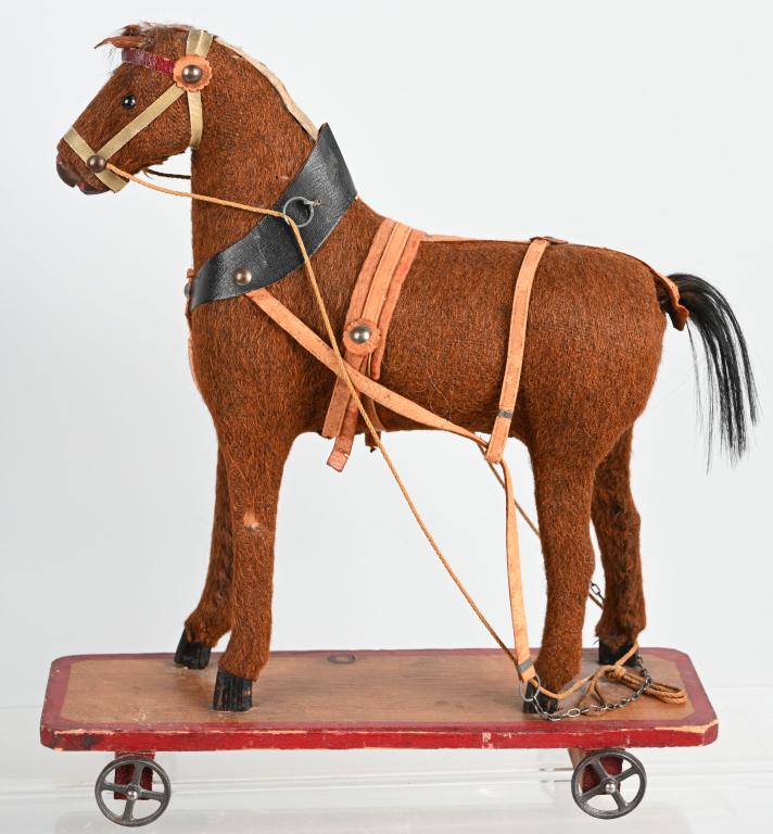 HIDE COVERED HORSE ON WHEELED PLATFORM: All original with nice details. Hide covered horse on wood platform with iron wheels. 14" Very Good