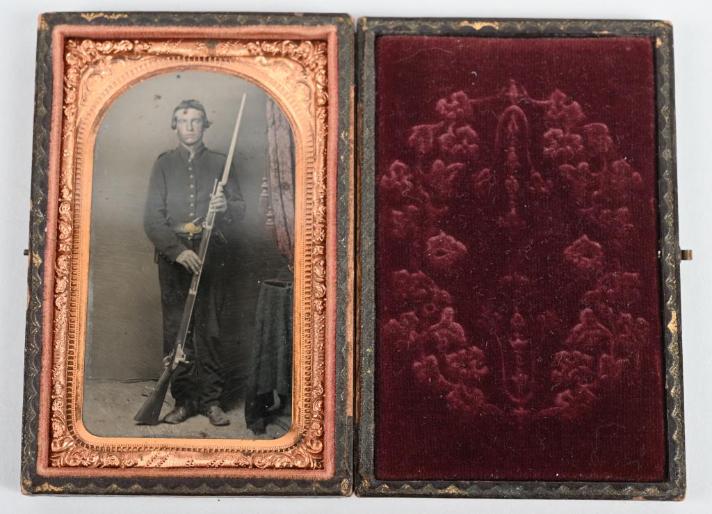 DOUBLE ARMED CIVIL WAR TINTYPE CASED RIFLE PISTOL: Civil War Double Armed tintype measuring 4 X 2 1/2 inches and is partially tinted. The full standing soldier is carrying a M1861 Springfield Rifle and what looks like a Colt Army M1860 in his belt. Th