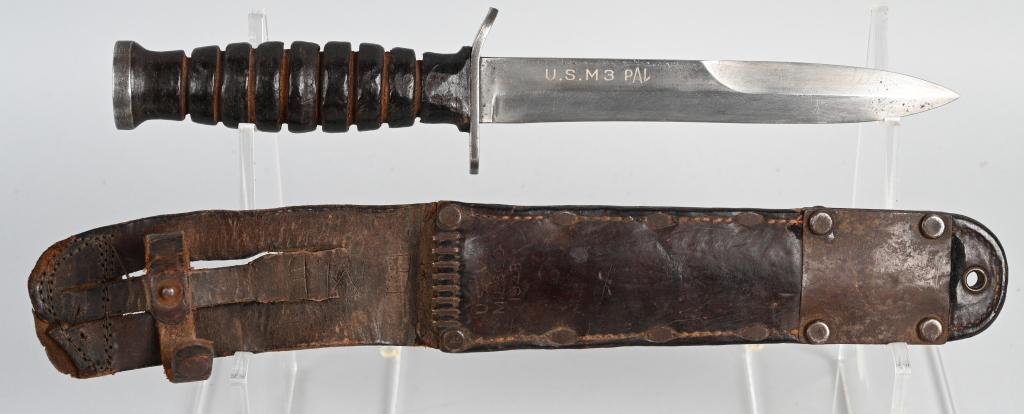 WWII US M3 FIGHTING KNIFE BLADE Mkd. PAL + SHEATH: World War II M3 Fighting Knife. Made by PAL, marked on the blade. Stacked leather washer handle, with Ordnance bursting bomb proof mark on the pommel. Blade shows light service wear. Comes in original