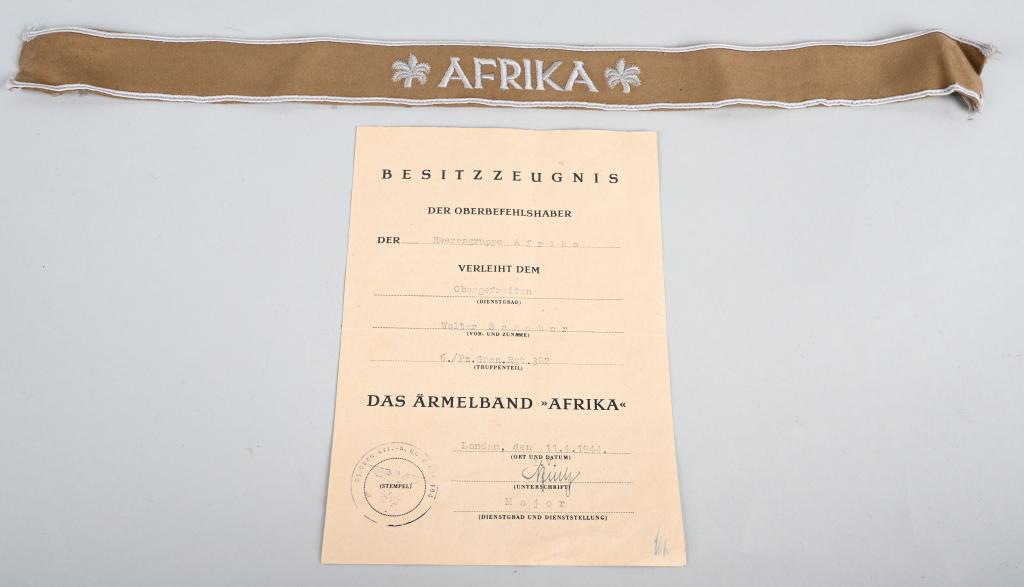 WW2 GERMAN NAZI PANZER AFRIKA CUFFTITLE + DOCUMENT: Rare WWII Nazi German Afrika Cufftitle document and cufftitle named to Obergefeiten Walter Schober of the 382nd Panzer Grenadier Regiment 6th Company. The document reads "BESITZZEUGNIS DER OBERBEFEHLS