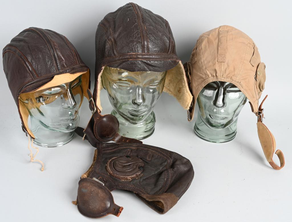 WWII US NAVY GROUP OF 4 FLIGHT HELMETS USN WW2: Grouping of 4 US Navy flight helmets to include 1) US NAVAL AVIATOR NAF-1092 FLIGHT HELMET. Brown leather flight helmet designed for use by U.S. Navy pilots in World War Two. Features three attached l