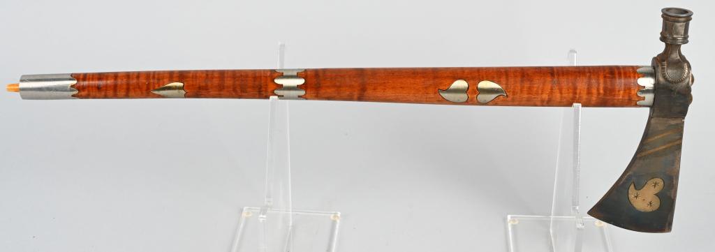 CONTEMPORARY PEACE PIPE WITH HEART MOTIF: Contemporary peace pipe with fine inlays of brass and German silver. The head has a heart motif, 19 inches in total length and the pipe functions properly with tiger stripe maple wood handle.