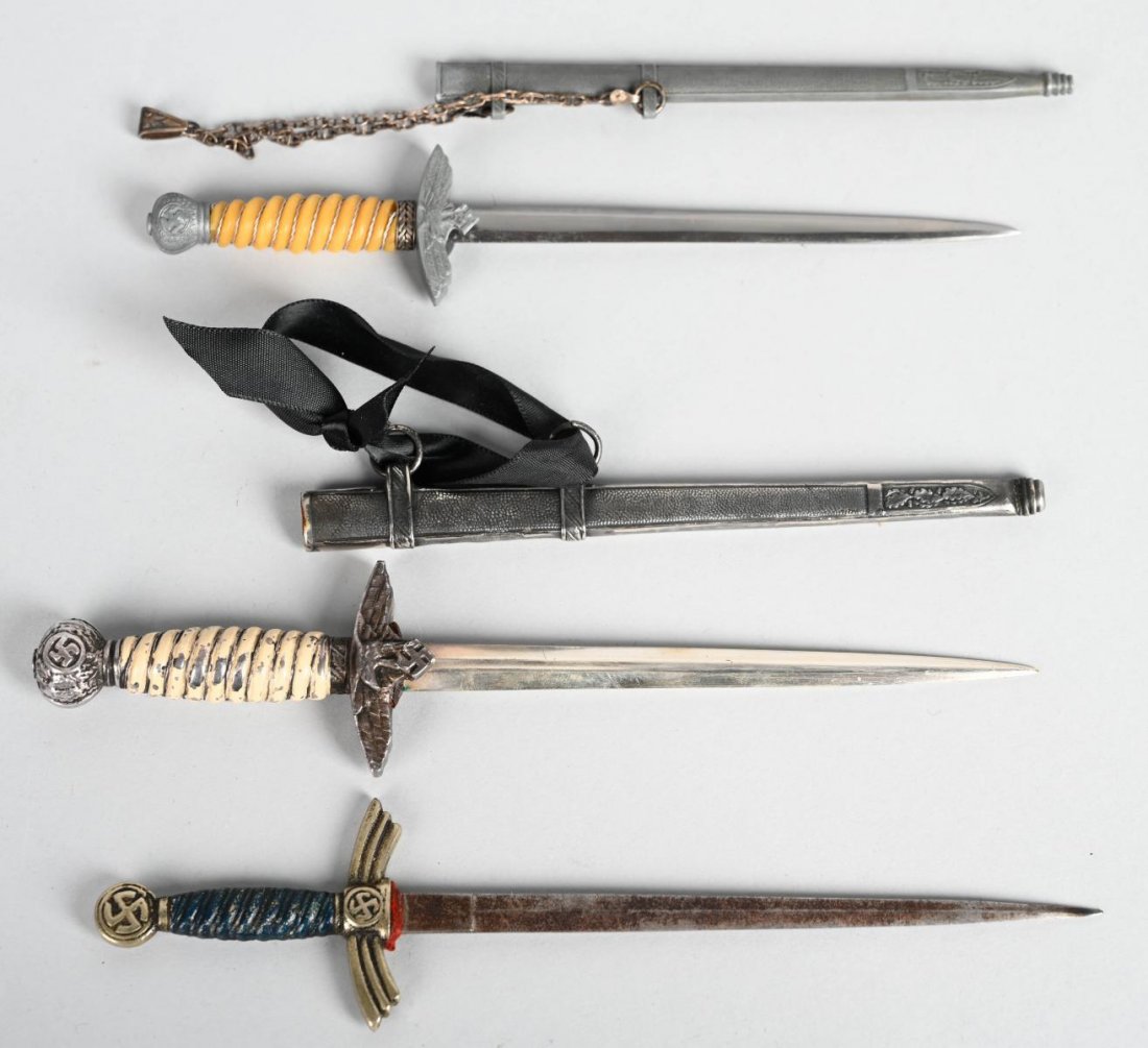 3 MINIATURE NAZI LUFTWAFFE DAGGERS: Three miniature Luftwaffe daggers. Includes all metal replica of the 1st Model Luftwaffe dagger with scabbard, and two variants of replicas of a 2nd Model Luftwaffe Officer\'s Dagger. Longest one meas