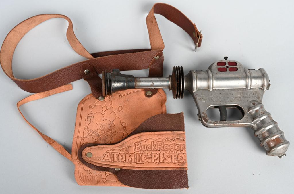 DAISY BUCK ROGERS ATOMIC PISTOL w/ HOLSTER: The Buck Rogers pistol works, but has scattered surface rust. The original leather holster has light wear. 9 1/2", Very Good