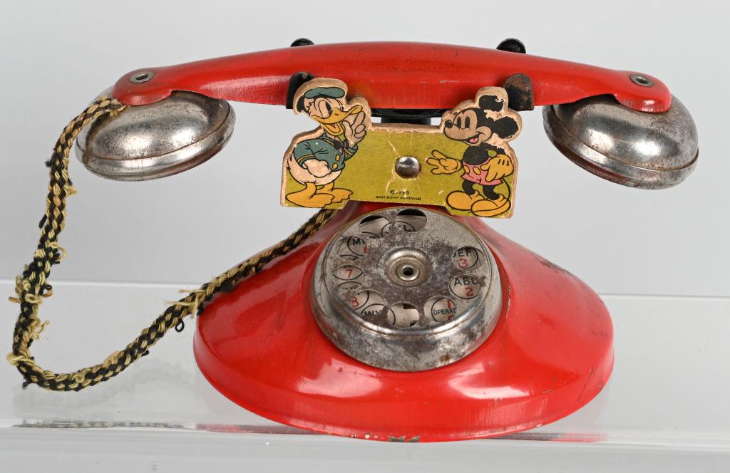 WDE Mickey Mouse & Donald Duck Telephone: Early Walt Disney Enterprises metal telephone with Mickey Mouse and Donald Duck figures. 8" Very Good