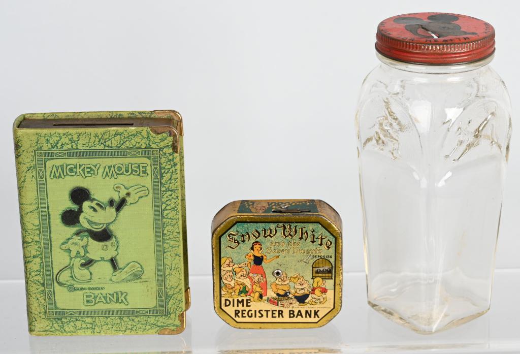 3- WDE DISNEY BANKS, MICKEY MOUSE & SNOW WHITE: Nice lot of pre-war Disney banks. Lot includes an embossed glass Mickey Mouse Jam Jar bank, a Mickey Mouse book Savings bank, along with a tin Snow White Dime Register bank. Largest is 6", Very Good-E