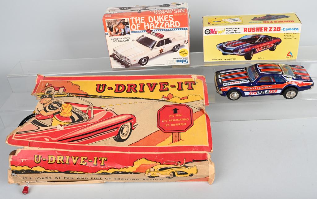 VINTAGE TOY LOT: Lot includes a Chevrolet Camaro Rusher Z28 with original box, a Dukes of Hazzard Model Kit of Sheriff's Roscoe's Police Car, along with an incomplete U-Drive-It toy with the original box. Mechanical t