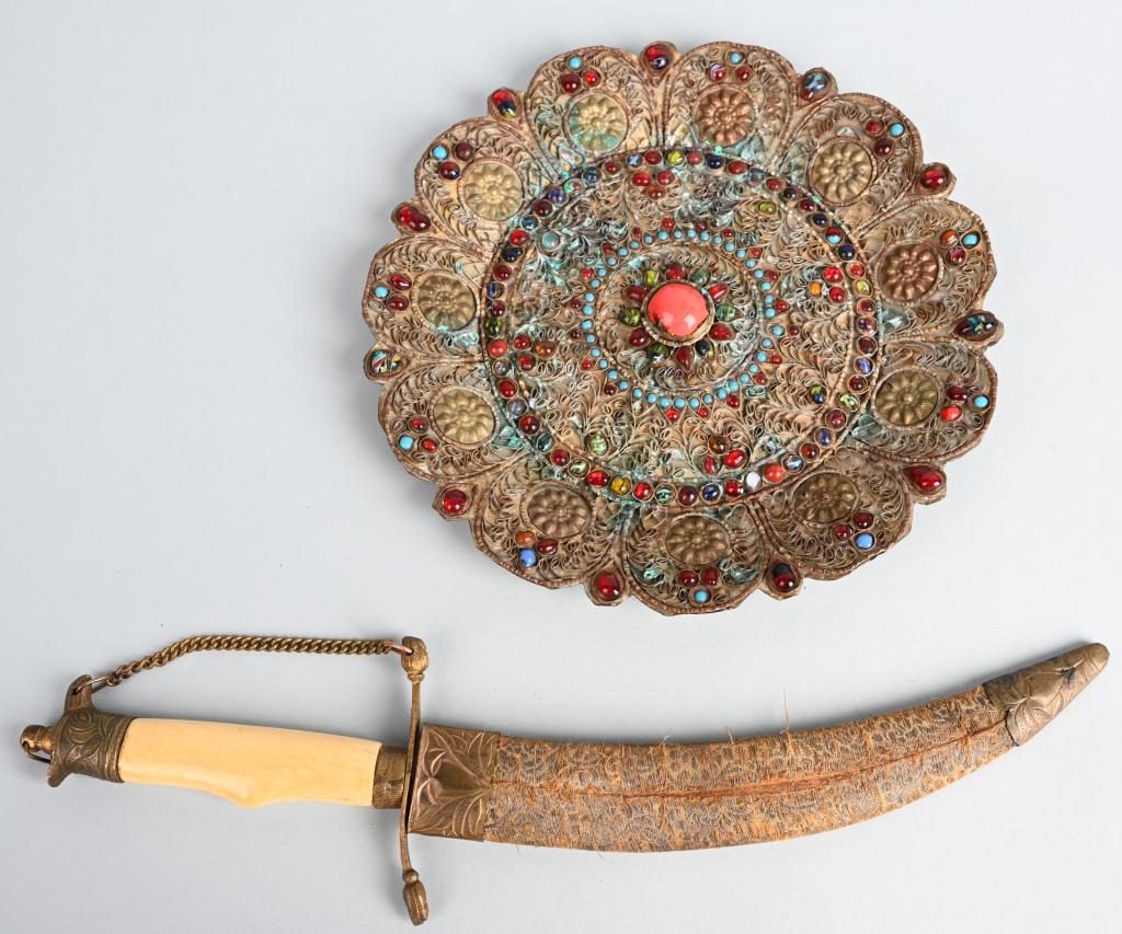 MID EAST BIRD HEAD DAGGER & BEADED BRASS PLATE: Dagger has brass mounting and bone grip. The etched blade is 8", and the dagger is 13" overall. The brass plate is adorned with brass wire and glass beads. It is almost 9" diameter. Very Good-Excellen