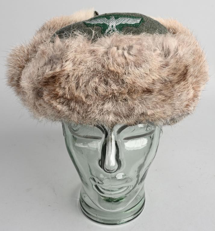WII NAZI GERMAN CUSTOMS OFFICIAL'S WINTER FUR CAP: Field-gray wool construction cap with slightly mottled brown rabbit fur front, fold down side ear lugs and back panels. The side ear lugs and back panel of the cap are held in the upright position by 