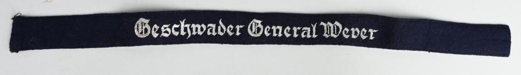 WWII LUFTWAFFE GESCHWADER GENERAL WEVER CUFFTITLE: Roughly 36mm tall 51cm long EM/NCO's pattern deep navy blue woven wool construction cufftitle with machine embroidered Gothic styled script "Geschwader General Wever" in silver bullion threads. The cu