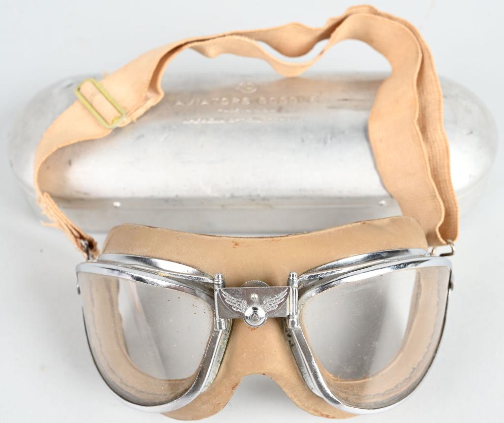 WWII US ARMY AIR CORPS FLIGHT GOGGLES AO WW2 CASED: WWII US Army Air Force flying goggles made by AMERICAN OPTICAL with "AO" maker's mark on the adjustable bridge. Clear rock glass lenses. Complete with original aluminum case stamped AVIATORS GOGGLE MA