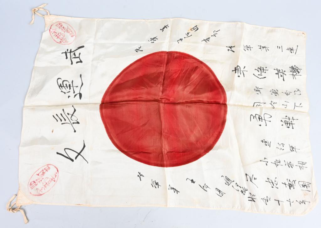 WWII JAPANESE KANJI SIGNED FLAG: Silk Unit flag with printed red circle "Meatball" in the center. Has red stamps and kanki characters. Measures approximately 18" x 26" and has reinforced corners and string ties. Light age spots, like