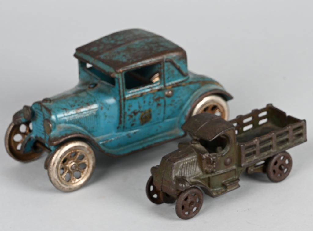 ARCADE CAST IRON ROADSTER & STAKE TRUCK: Original Arcade Roadster. Has factory paint and nice Arcade sticker on door. Missing rumble seat lid and has minor ship on rear fender. Plus Mack Stake Bed Truck with most paint missing. Largest 6 1/2