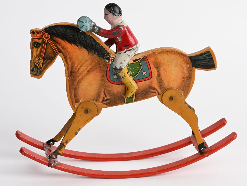 GIBBS USA 1910 BOY ON ROCKING HORSE: Very nice original hand painted tin boy riding on paper litho wood rocking horse. Nice original condition with bright colors. One tab missing on horse hoof. Hard toy to find in this condition. 9" by 7