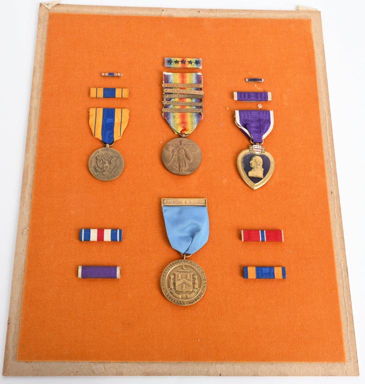 WWI NAMED PURPLE HEART GROUPING W MEDALS WWII: WW1 Father and WWII son medal and ribbon bar grouping to include 1) 1932 Numbered Purple Heart with ribbon bar and Rosette named to Raymond E. Steel and is officially engraved by the US Government. Nu