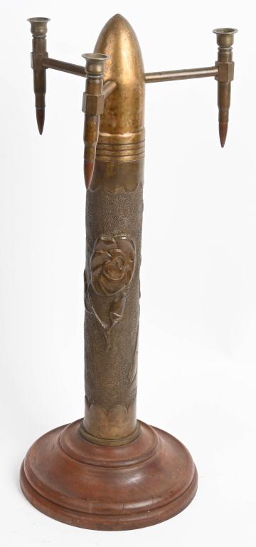 WWI TRENCH ART SHELL W/ INDIANS SHOOTING A BOW WW1: WWI era Large size Artillery Shell made into a Candelabra measuring 27 inches in total height and using .50 Cal shells for placement of the Candle's. The shell shows two Indians or Native Americans in