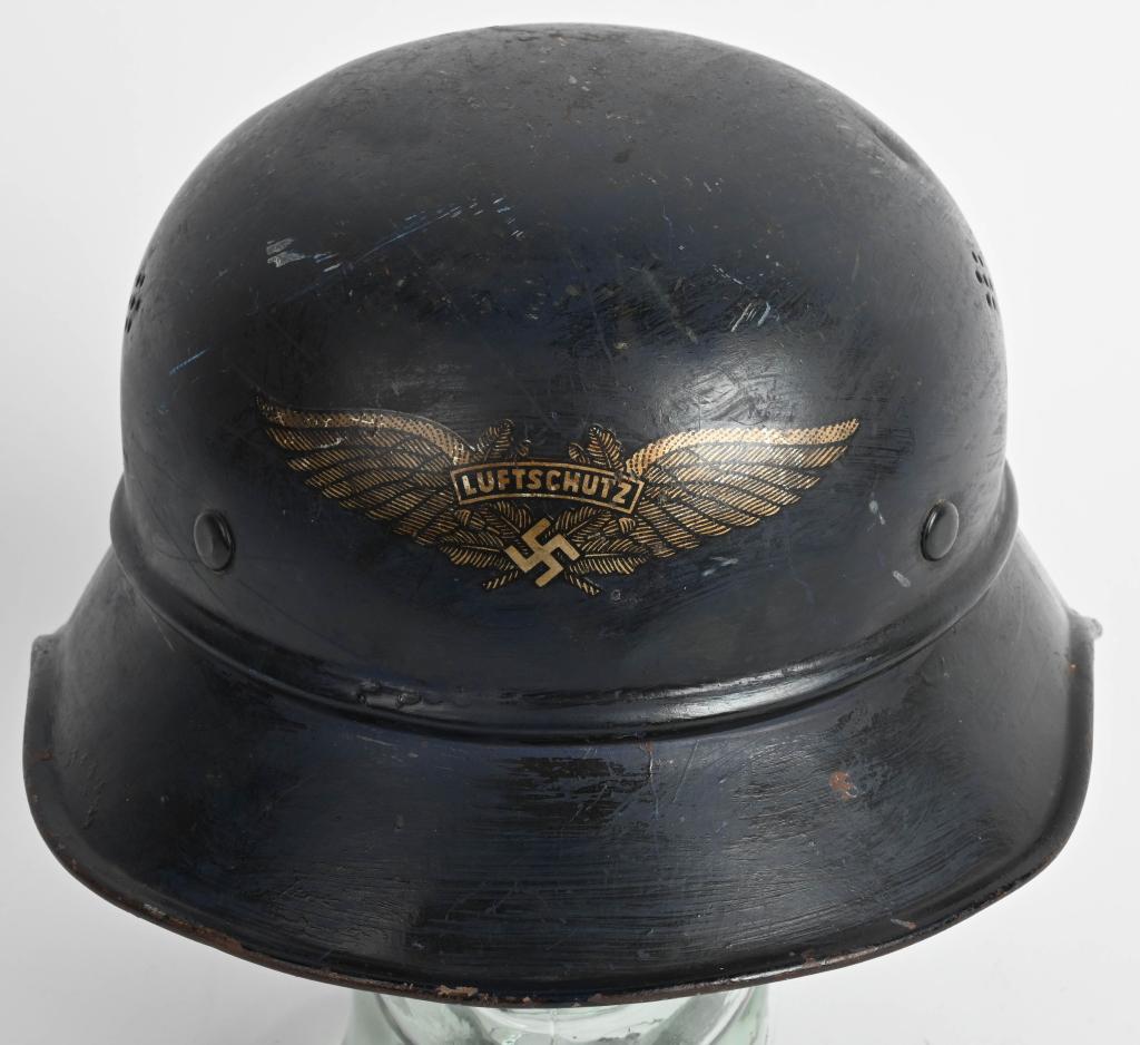 WWII LUFTSCHUTZ BEADED M38 GLADIATOR HELMET WW2: The three piece, stamped, sheet steel construction Luftschutz M38 "Gladiator" style helmet retains a most of its original, smooth, dark satin blue paint. The front center of the helmet has a Luftschut