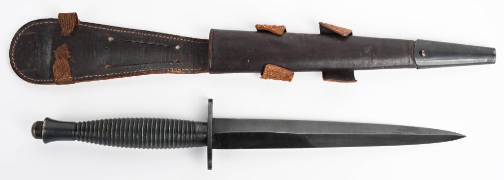 BRITISH FAIRBAIRN SYKES FIGHTING KNIFE W/ SHEATH: A third pattern Fairbairn-Sykes fighting knife with a 17cm stiletto style blade with high central spine. The cast blackened brass handle, with twenty-seven concentric rings. The knife has a straight 2