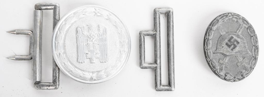 WWII NAZI GERMAN RED CROSS BELT BUCKLE WOUND BADGE: WWII Nazi German insignia lot to include 1) German World War II Silver Wound Badge. The front shows a German helmet with a pair of crossed swords in the center. All three are surrounded by an oval oak
