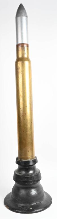DECORATIVE ARTILLERY SHELL WITH WOOD BASE: Large 120mm Artillery shell with intact iron and copper-banded artillery projectile head and tall wooden base. Head is painted silver. 62" tall and approximately 20" across at the base and will requir