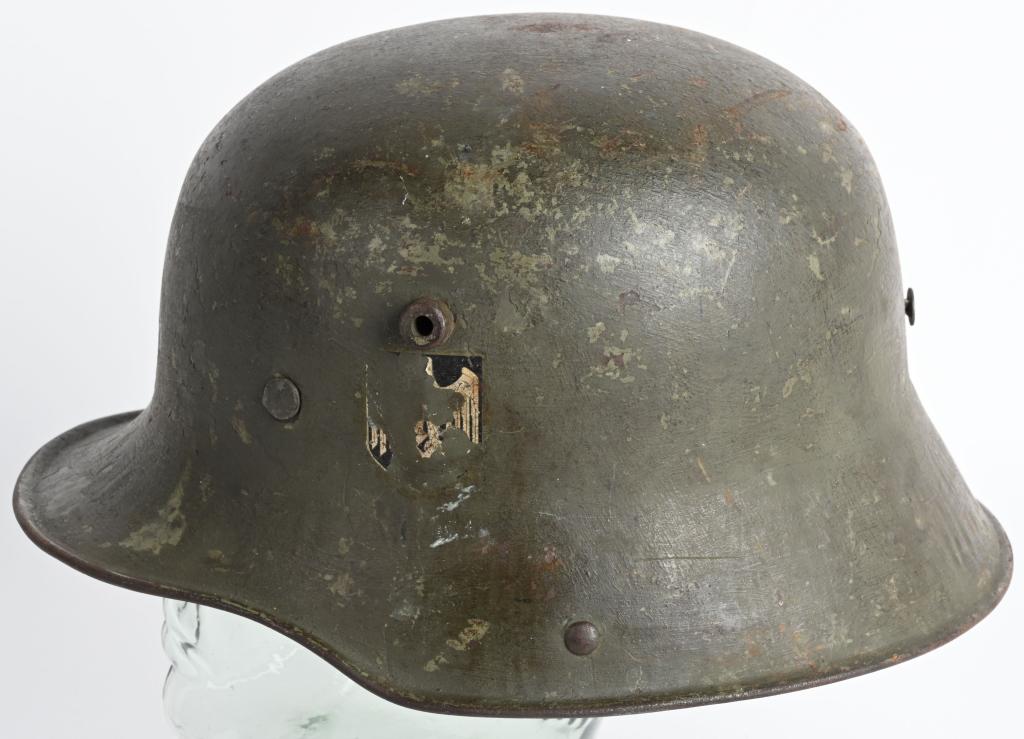 WWII NAZI M18 DOUBLE DECAL TRANSITIONAL HELMET WW2: The stamped sheet steel construction M18 helmet retains most of its green, transitional over-paint. The left side of the helmet has an Wehrmacht eagle decal which is retained about 15%. Tri-color is r