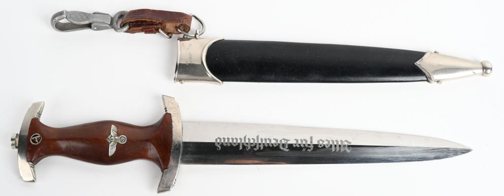 WWII NAZI GERMAN NSKK M33 DAGGER RZM M7/42 WW2: A NSKK EM’s dagger with its double-edged drop-forged nickel-silver blade in its original scabbard. The dagger has a plated pommel and tang nut. Its contoured wooden grip has inlaid to its obverse th